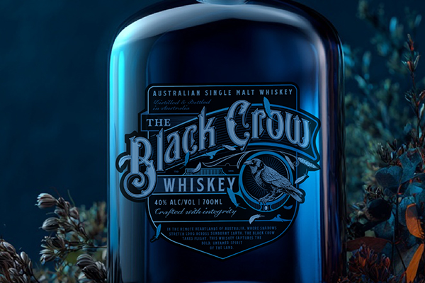 Black Crow single malt whiskey bottle among native botanicals